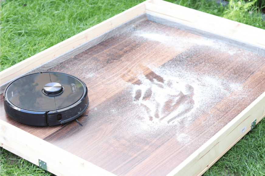 Roborock S6 в испытательной зоне удаляет песок с твердого пола.